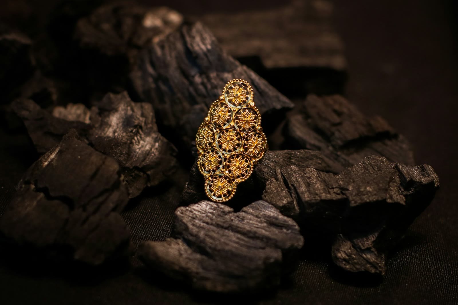 Un anello in filigrana d'oro su fondo scuro